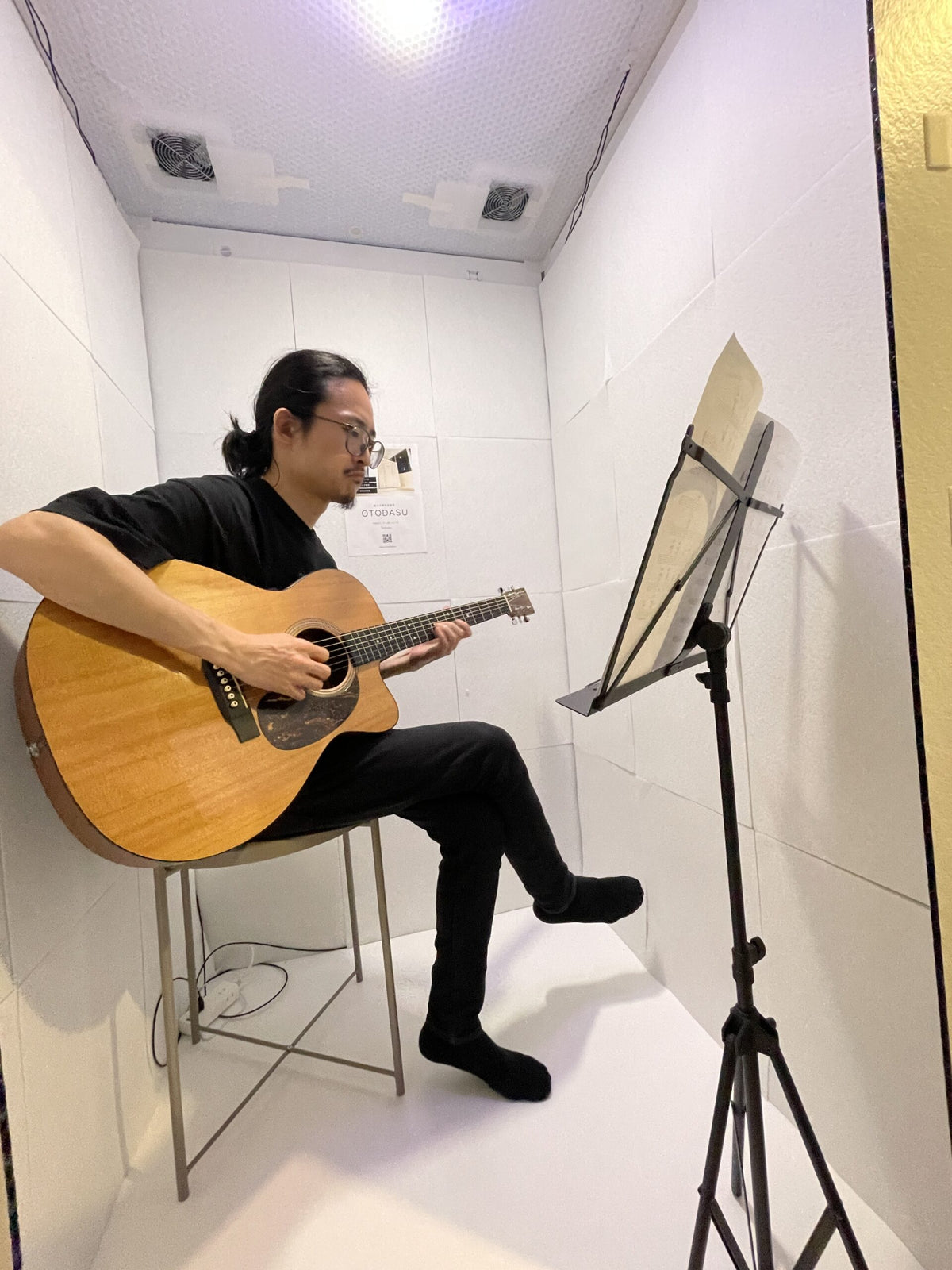 組み立て式簡易防音室 OTODASU Ⅱ 吸音材付き（ホワイト）：内部でアコースティックギターを譜面台で練習する男性