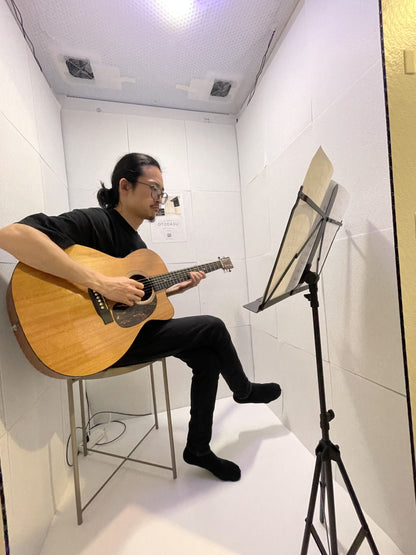 組み立て式簡易防音室 OTODASU Ⅱ 吸音材付き（ホワイト）：内部でアコースティックギターを譜面台で練習する男性