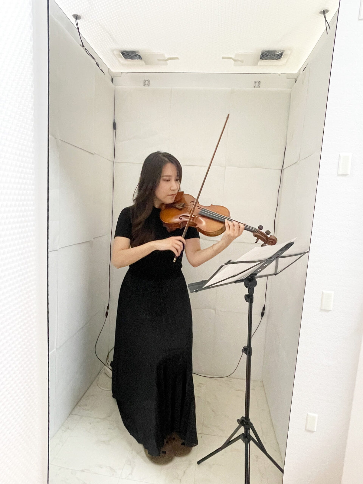 組み立て式簡易防音室 OTODASU Ⅱ 吸音材付き（ホワイト）：内部でバイオリンを演奏する黒いドレスの女性